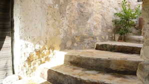 A stone staircase leading to an upper level, with a lantern hanging above and a small tree in the background. - L'Auberge De Tamezret (Matmata)