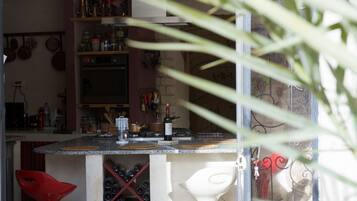 Una cocina con mostrador, un botellero y varios utensilios de cocina.