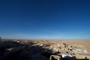 A desert landscape with a small settlement of buildings.