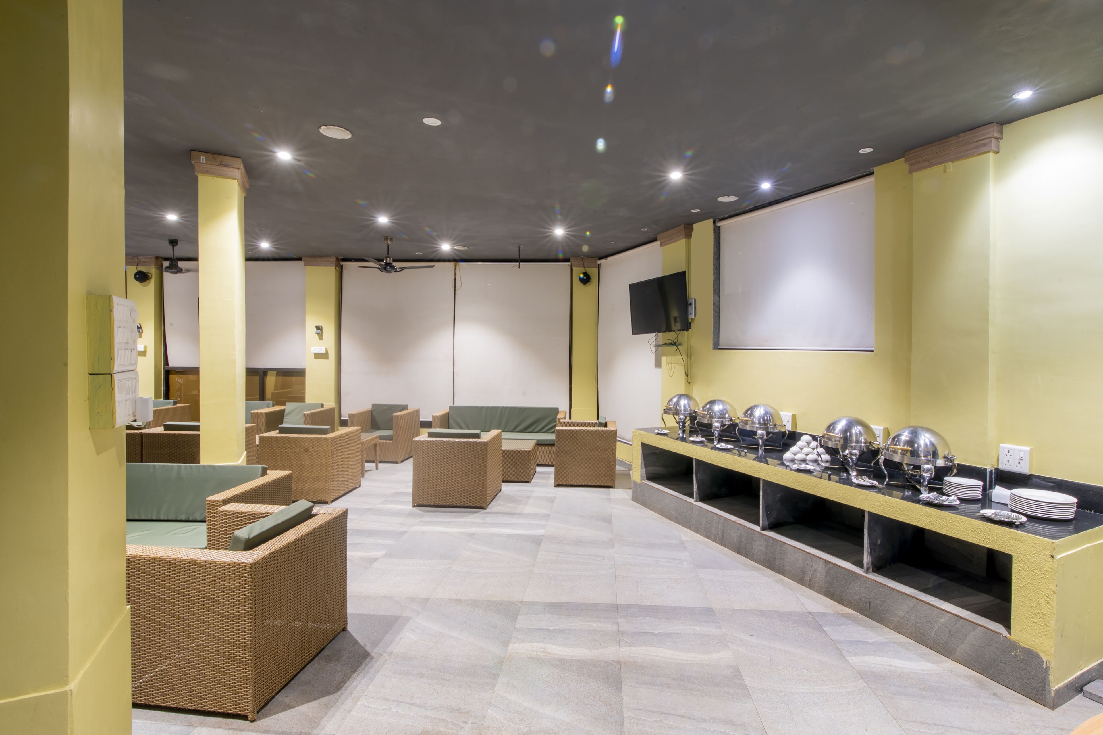 A room with wicker furniture, a buffet table, and a flat-screen TV on the wall.