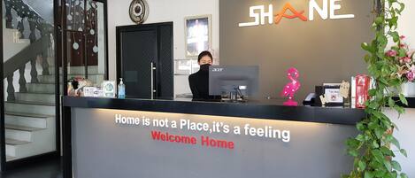 A reception desk with a sign that reads "Home is not a Place, it's a feeling Welcome Home."
