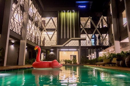 Una piscina al aire libre, sillones reclinables de piscina