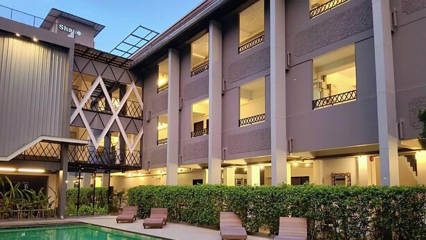 A hotel with a pool, lounge chairs, and a covered outdoor area with a geometric glass structure. - Shane Hotel Chiangmai (Chiang Mai)