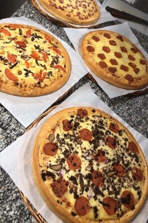 Trois pizzas sur un plan de travail en granit.