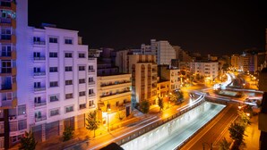 A nighttime cityscape with modern buildings, a well-lit road, and a bridge. - Hôtel Étoile du Nord (Tangier)