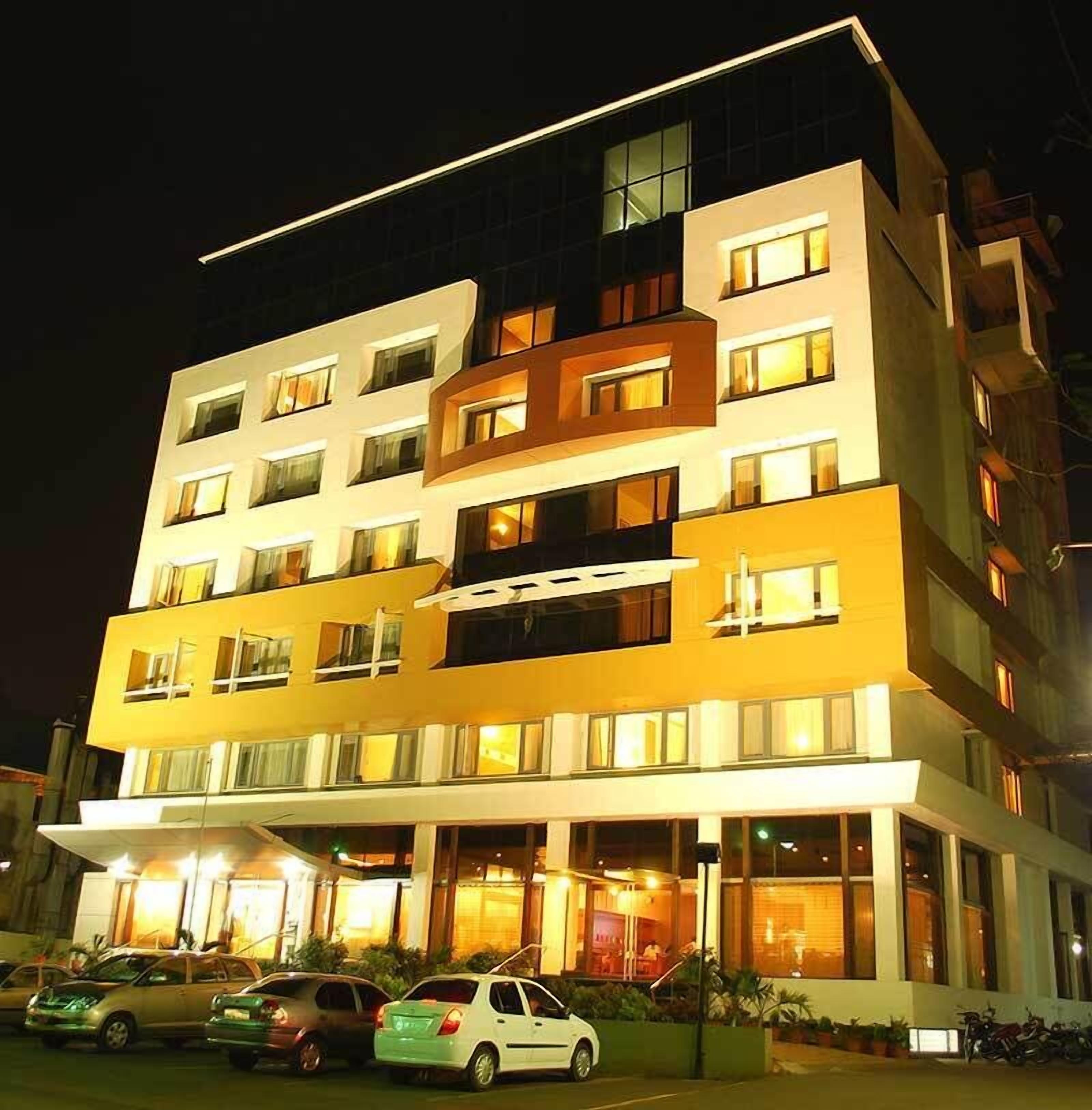A multi-story hotel with a modern design, featuring balconies and large windows.