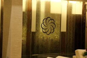 A wall with a logo and the word "Eefa" in a modern, reflective surface.