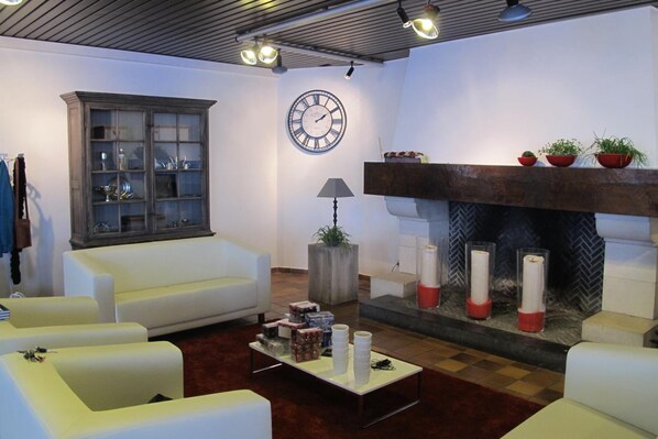 Una sala de estar con chimenea, un reloj y un armario.