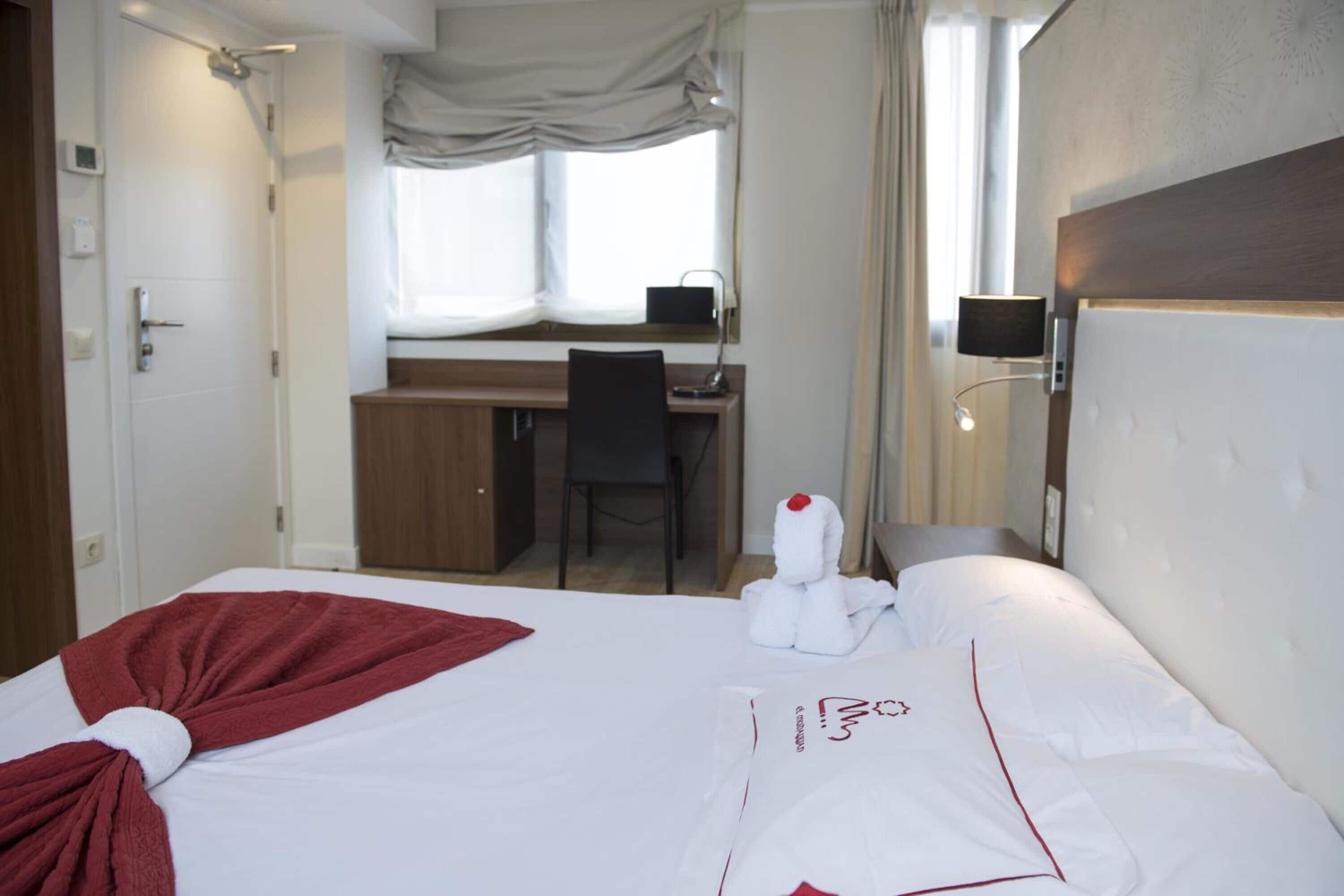 Una habitación de hotel con una cama, un escritorio y una silla.