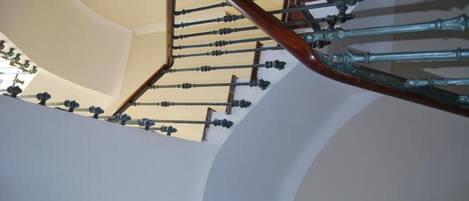A curved staircase with a wooden handrail and metal balusters.