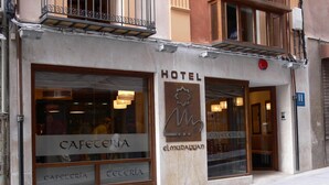 Un hotel con un letrero que dice "HOTEL" y "CAFETERÍA" en la fachada.