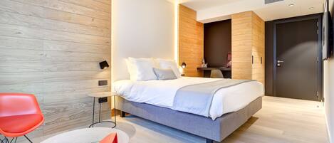 Quarto moderno com cama, duas cadeiras, mesa de cabeceira e guarda-roupa.