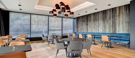Una sala de conferencias moderna con una gran mesa, sillas con diseño y un candelabro único.