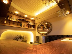 A bar area with shelves of liquor bottles, a mirror, and a coffee machine. - Exporoyal Hotel (Antalya)