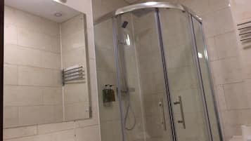 A modern bathroom with a glass-enclosed shower, a sink, and a mirror.