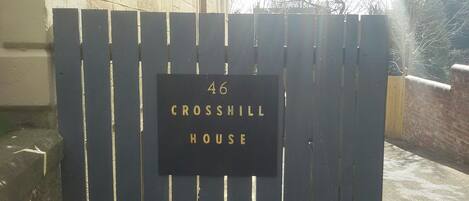Una reja de metal negro con un letrero que dice "46 CROSSHILL HOUSE".