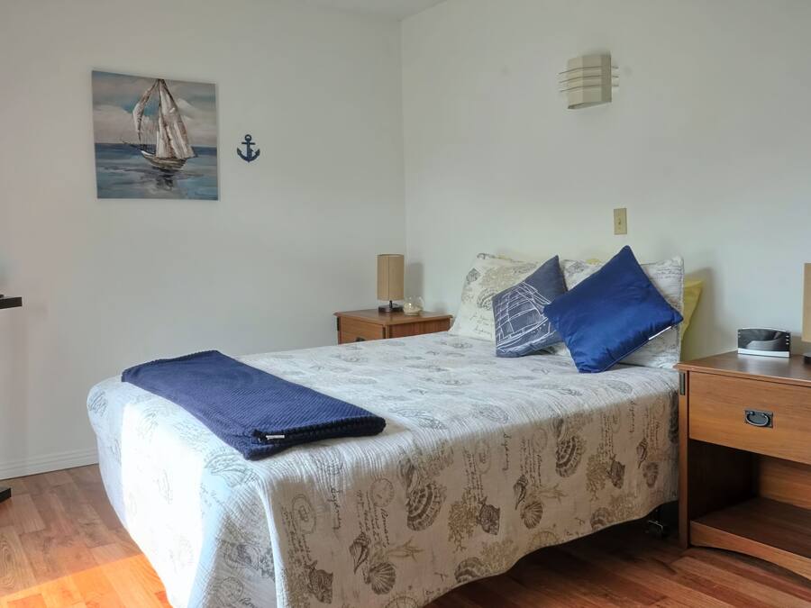 Ein Schlafzimmer mit einem Bett, einem Schreibtisch, einem Fernseher und einem Bild an der Wand.