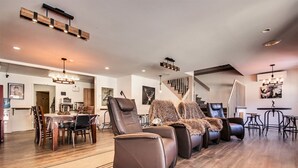 A spacious living area with leather recliners, a dining table, and a staircase. - Auberge Motel Drakkar (Shawinigan)