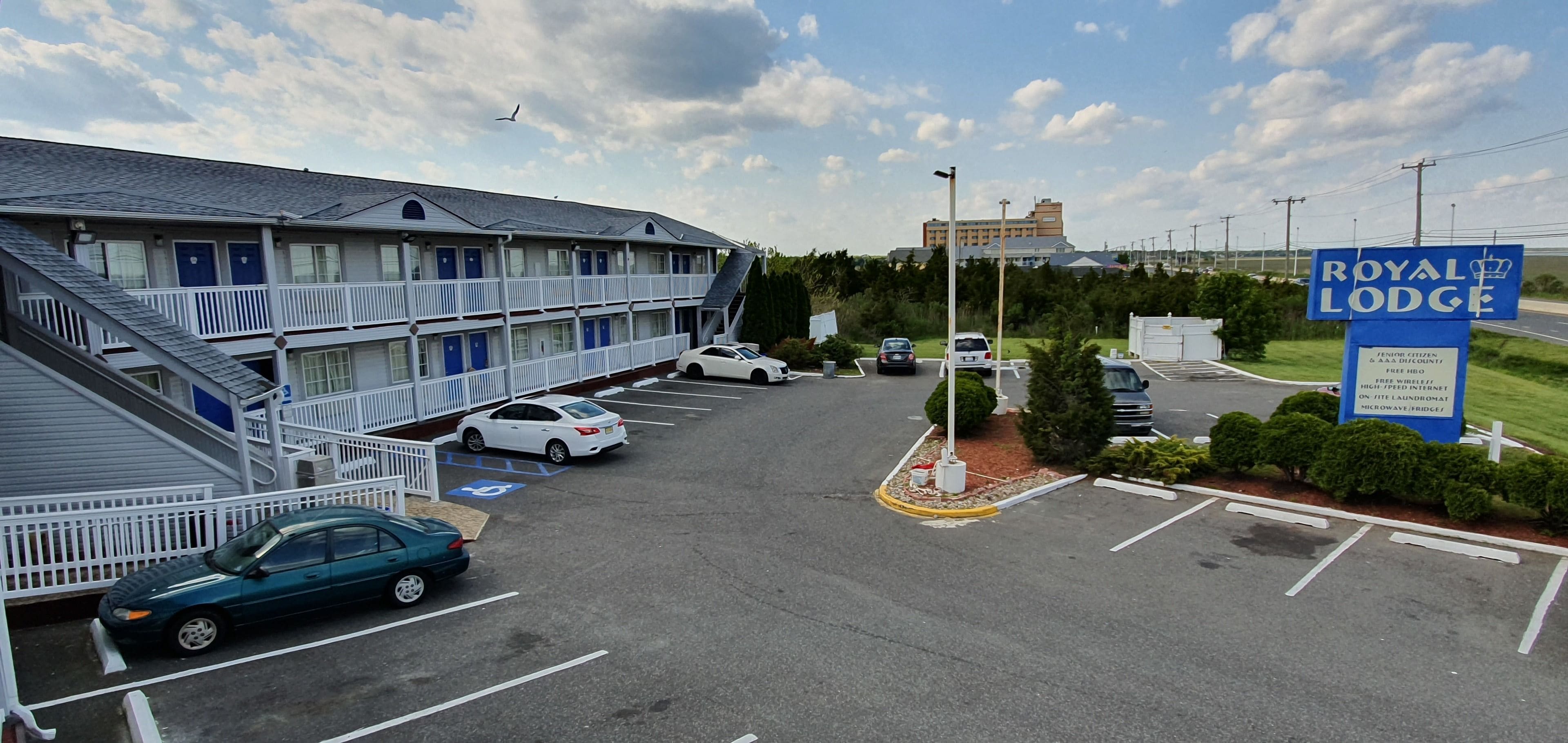 A parking lot with several cars, a motel building, and a sign for 'Royal Lodge'.