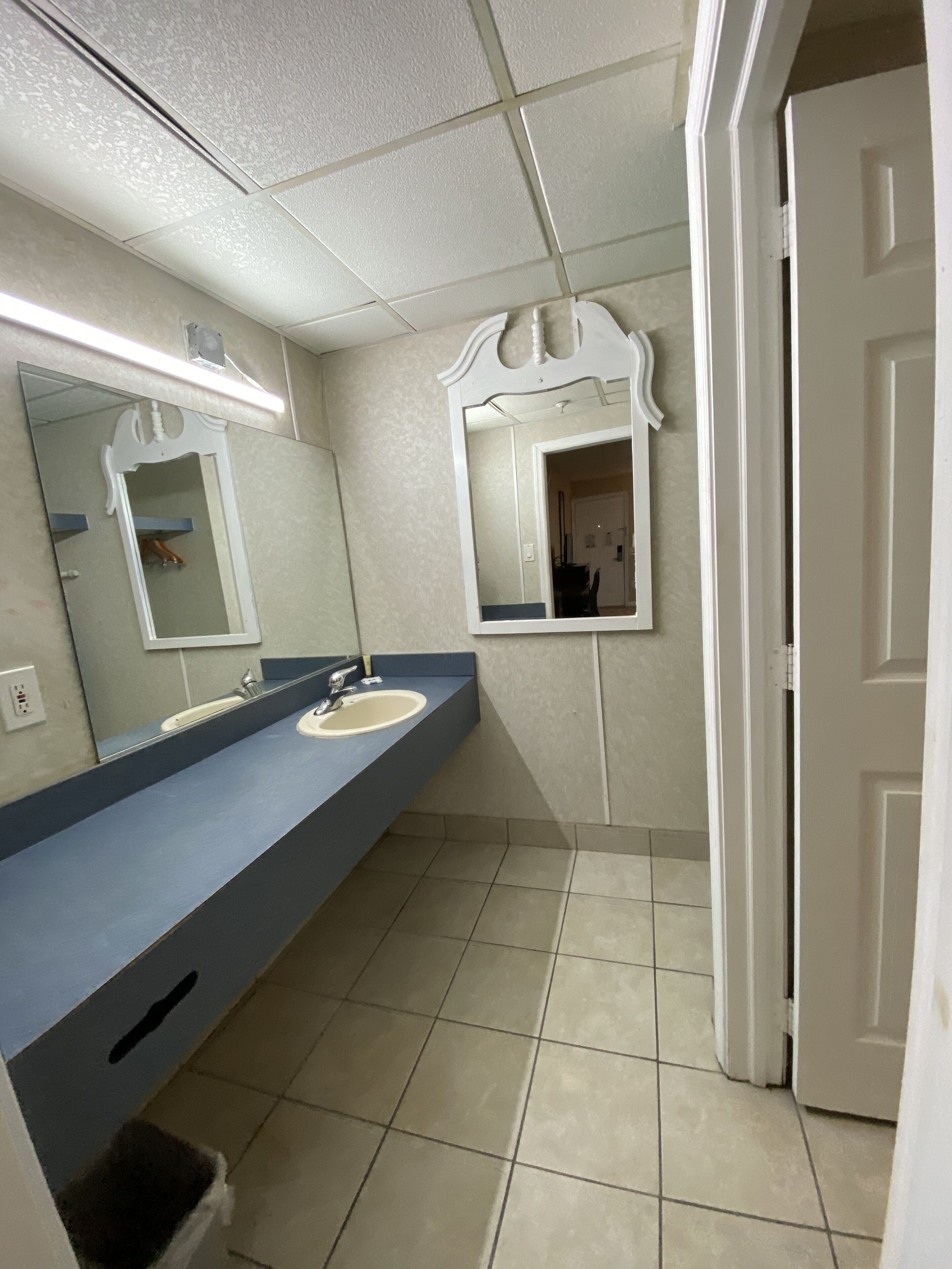 Un bagno con due lavandini, uno specchio e una porta.