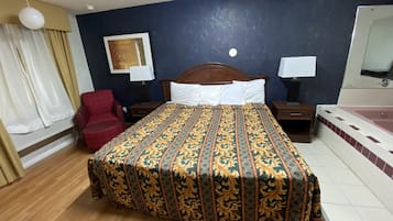Ein Hotelzimmer mit einem hölzernen Bett, einem roten Sessel, einem Nachttisch aus Holz, einem Beistelltisch und einem Badezimmer mit einer Badewanne.