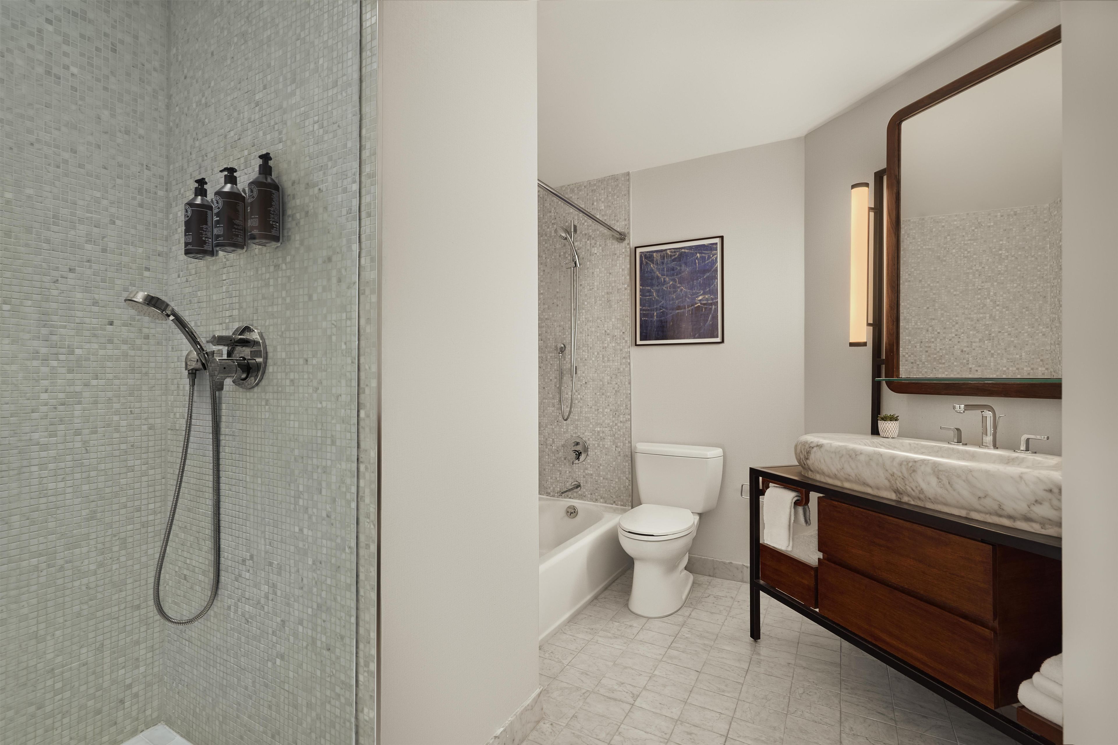 Un baño moderno con ducha, inodoro y tocador.