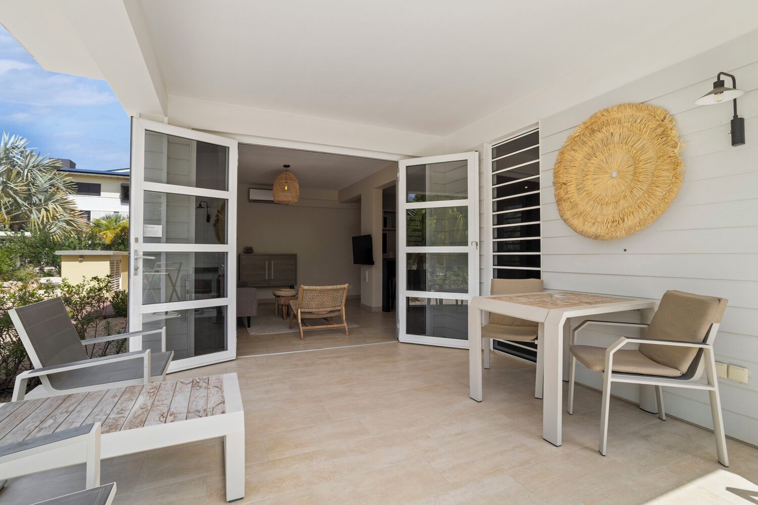 Un espacio habitable de concepto abierto con una mesa y sillas de comedor, un tapiz de pared tejido y vistas al exterior.