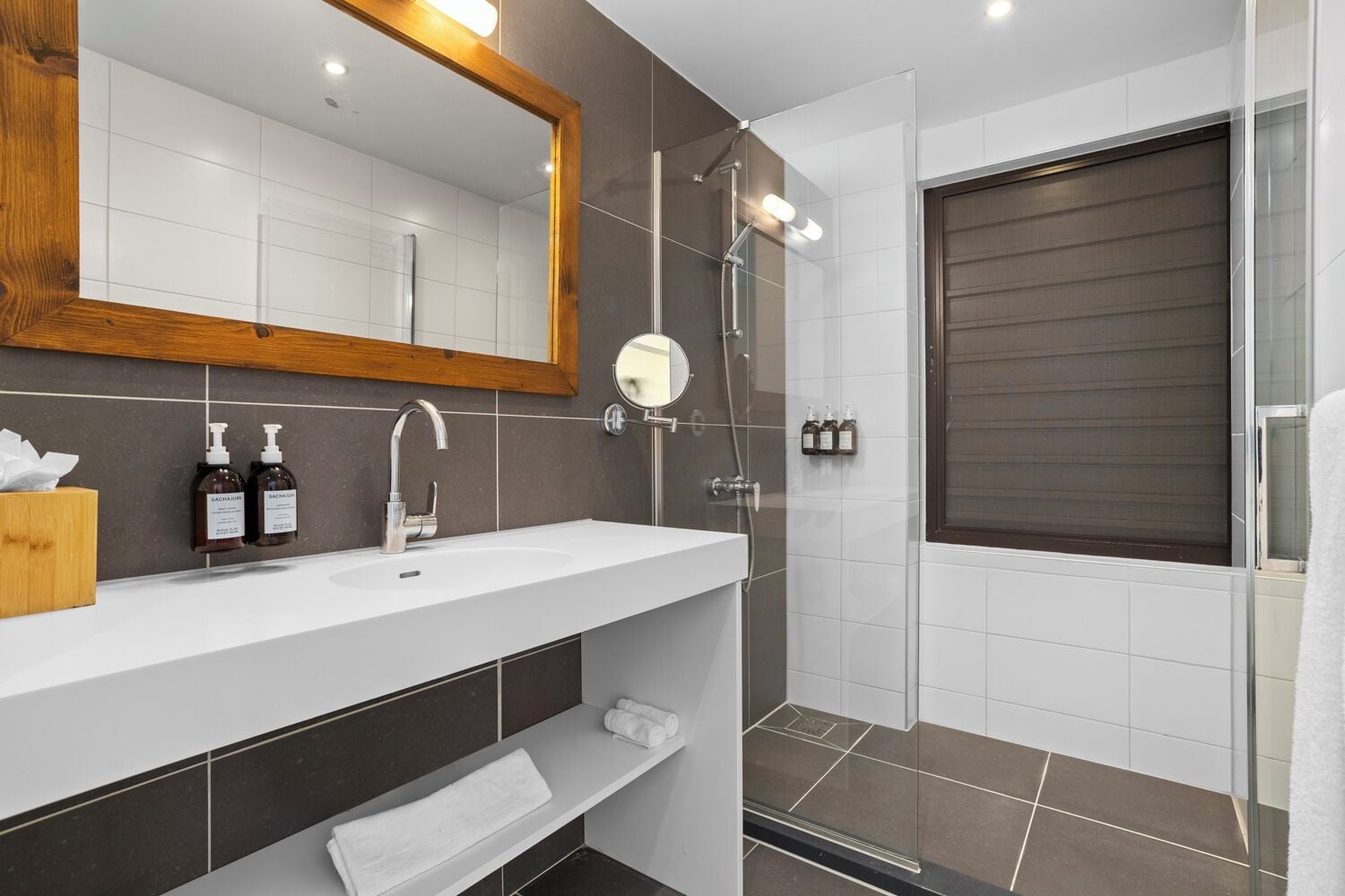 Une salle de bain moderne avec un lavabo blanc, un miroir et une douche.