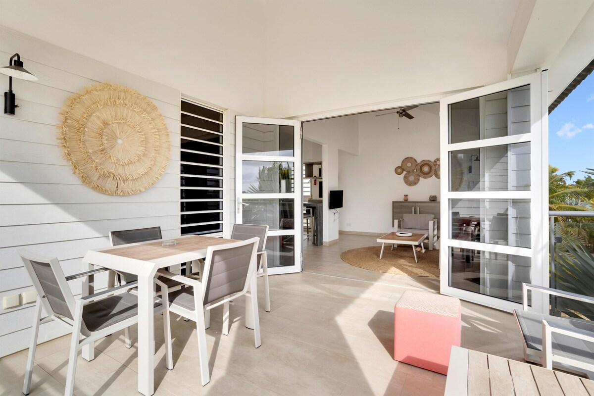 A modern interior with a dining area, open-plan living space, and large windows.