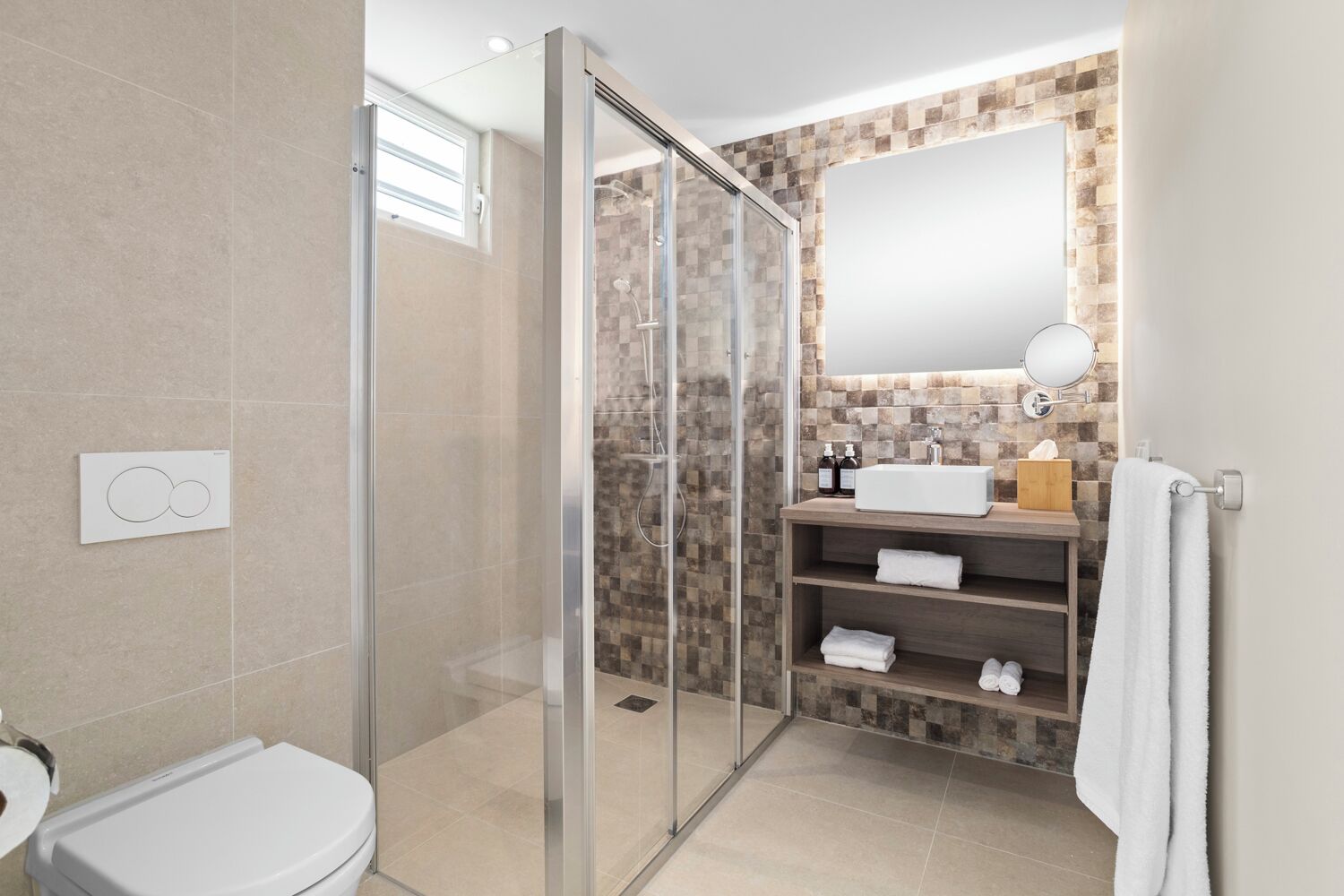 A modern bathroom with a glass shower enclosure, a white sink, and a mirror above it.