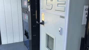 Máquina expendedora con la etiqueta 'ICE' y una puerta con un cartel que indica 'ICE & DRINKS'.