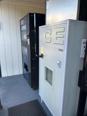A vending machine labeled 'ICE' and a door with a sign indicating 'ICE & DRINKS' available. - Welcome Inn on Colorado Blvd (Los Angeles)