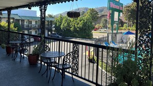 A covered outdoor area with tables and chairs, a Welcome Inn sign, and a view of a street with cars and buildings. - Welcome Inn on Colorado Blvd (Los Angeles)