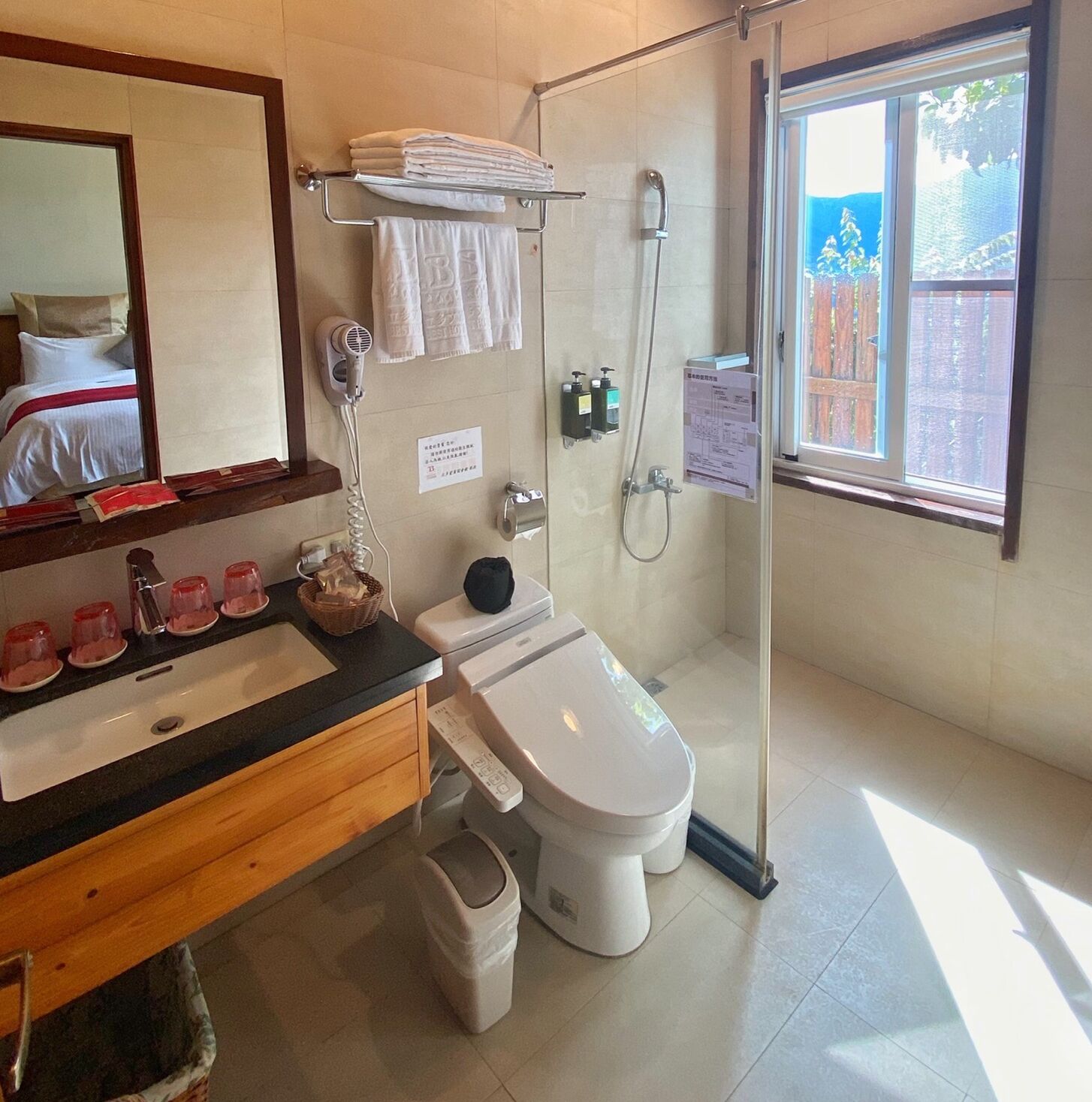 A modern bathroom with a glass shower enclosure, a sink with a vanity, a toilet, and a mirror.