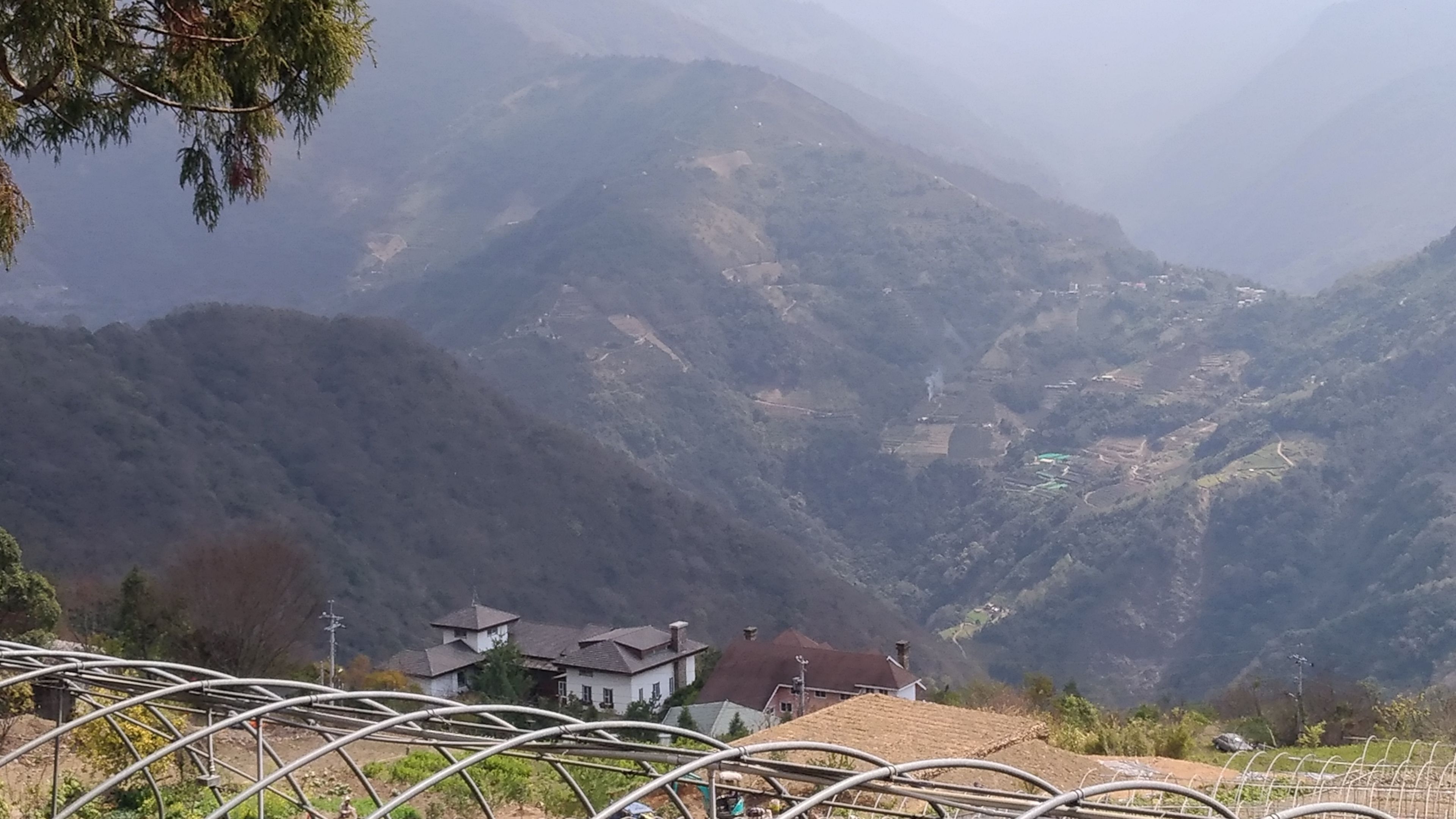 A mountainous landscape with a few buildings at the base.