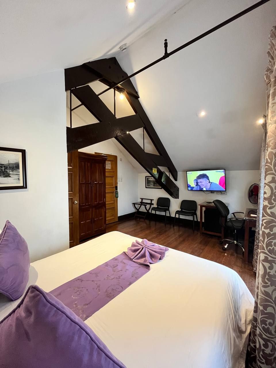 Een slaapkamer met een bed, een bureau, een stoel en een televisie.