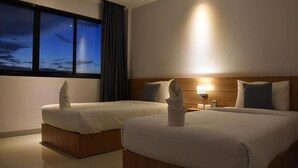 A hotel room with two beds, a night sky view, and a bedside table with a lamp. - B Boutique Residence (Surat Thani)