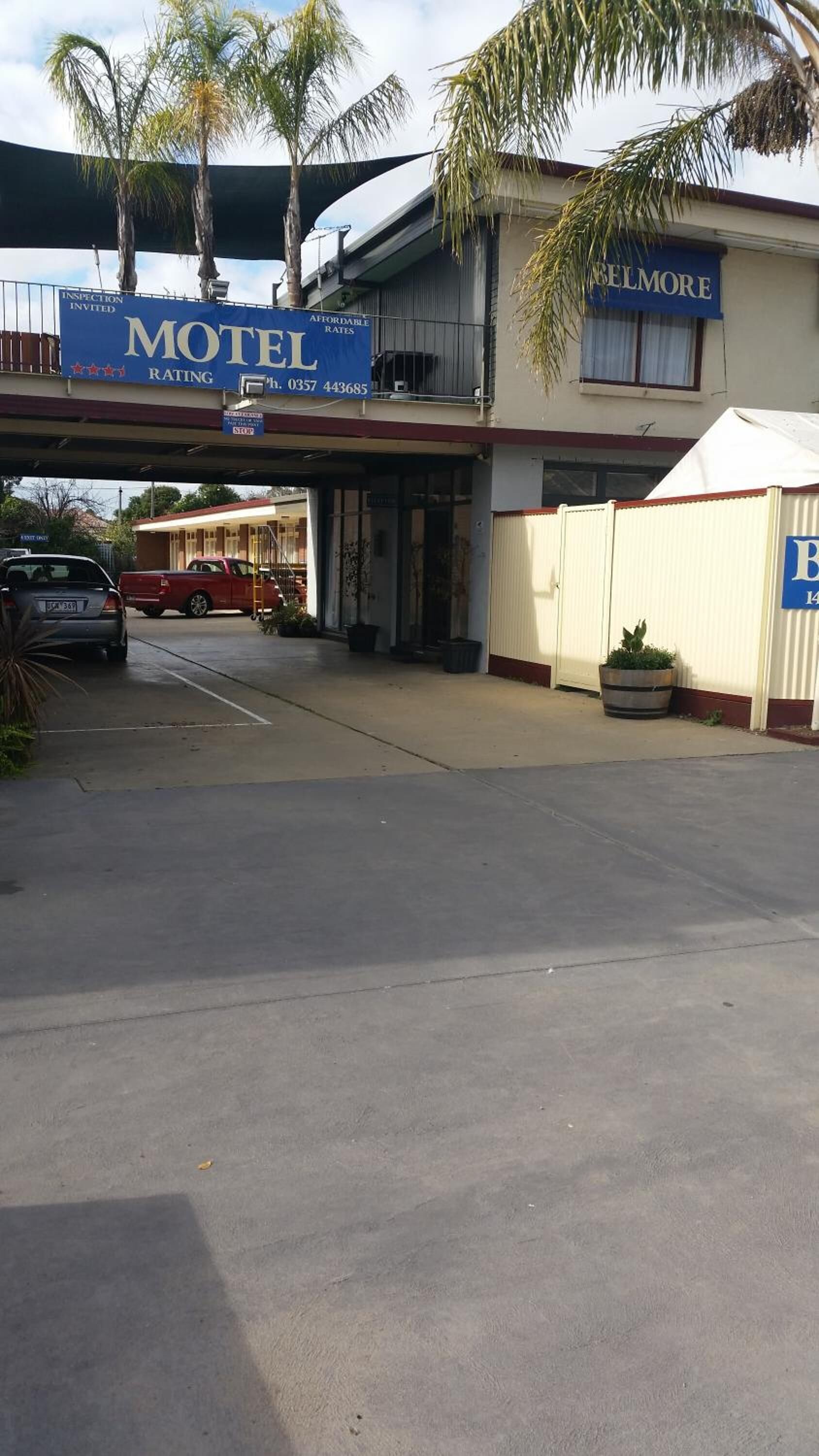 A motel with a signboard advertising affordable rates and a phone number.