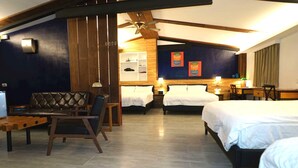Une chambre d’hôtel équipée d’un lit, d’un bureau, d’une chaise, d’une petite table et d’un ventilateur de plafond.