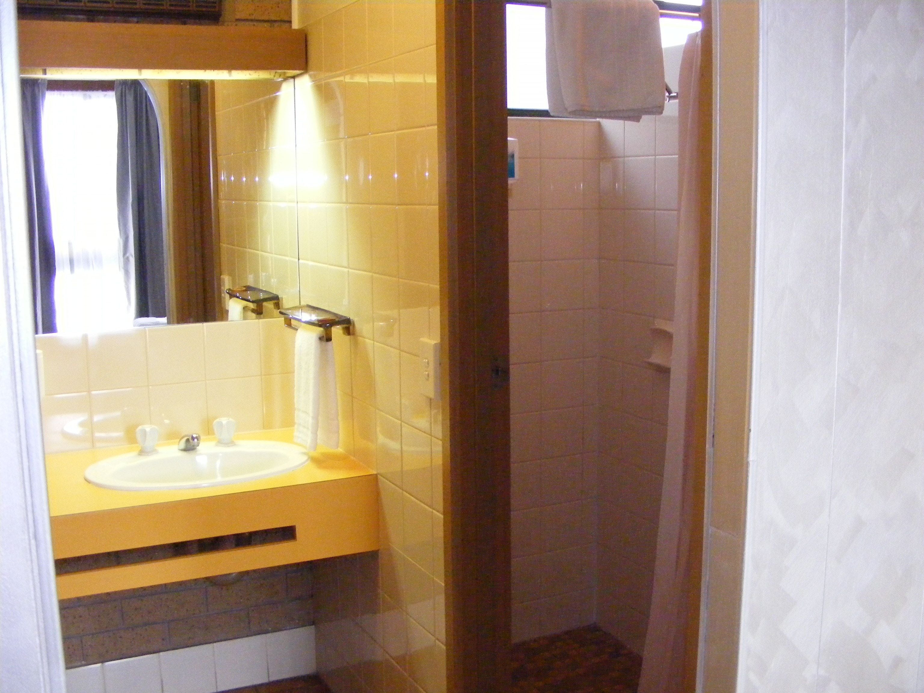 A bathroom with a sink, mirror, and towel rack.