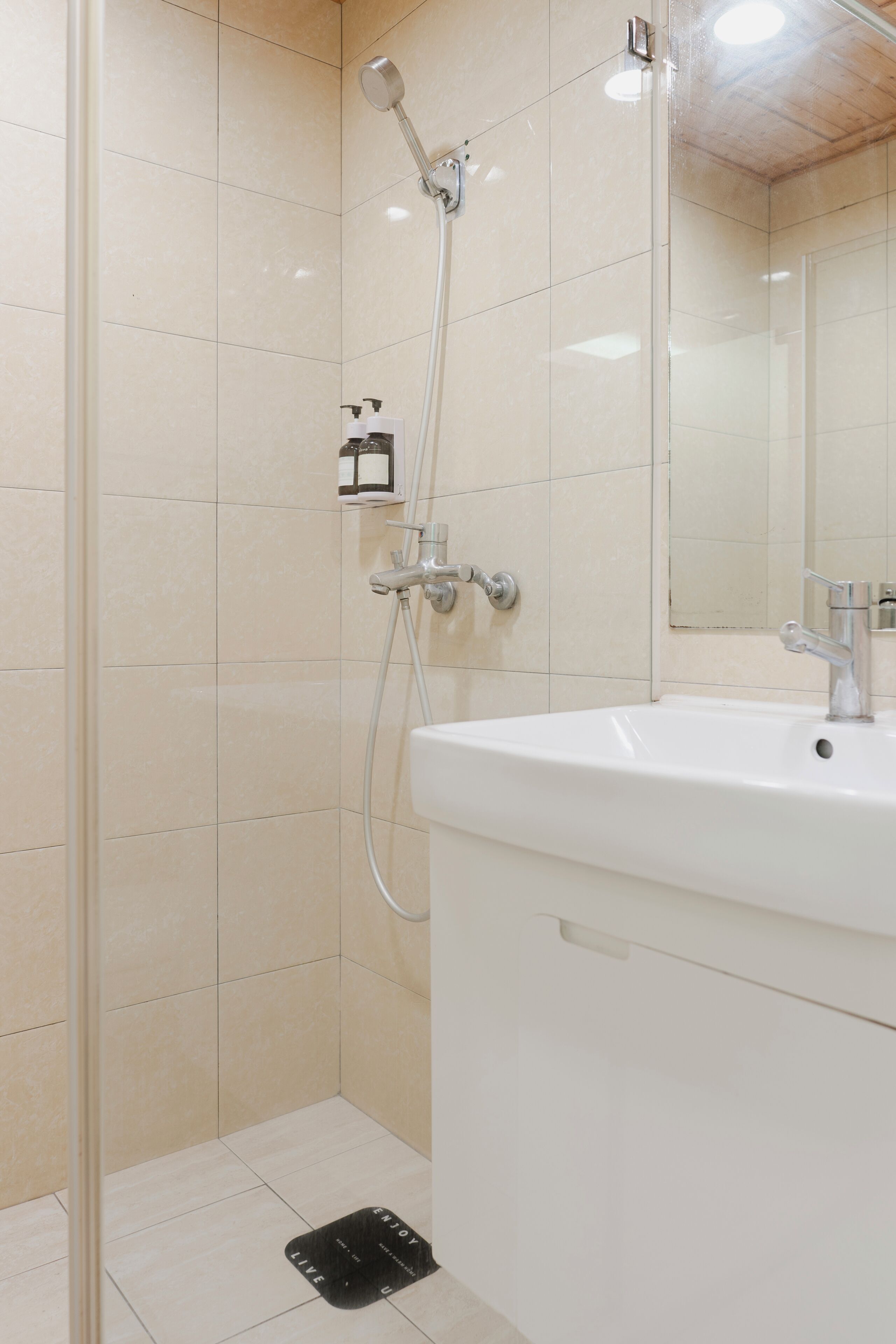 A modern bathroom with a shower, sink, and mirror.