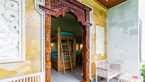 Una habitación con una escalera de madera, un banco de madera y una silla blanca.