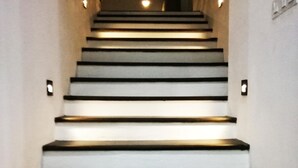 A staircase with alternating black and white steps, illuminated by wall-mounted lights. - Leighton Resort (Negombo)