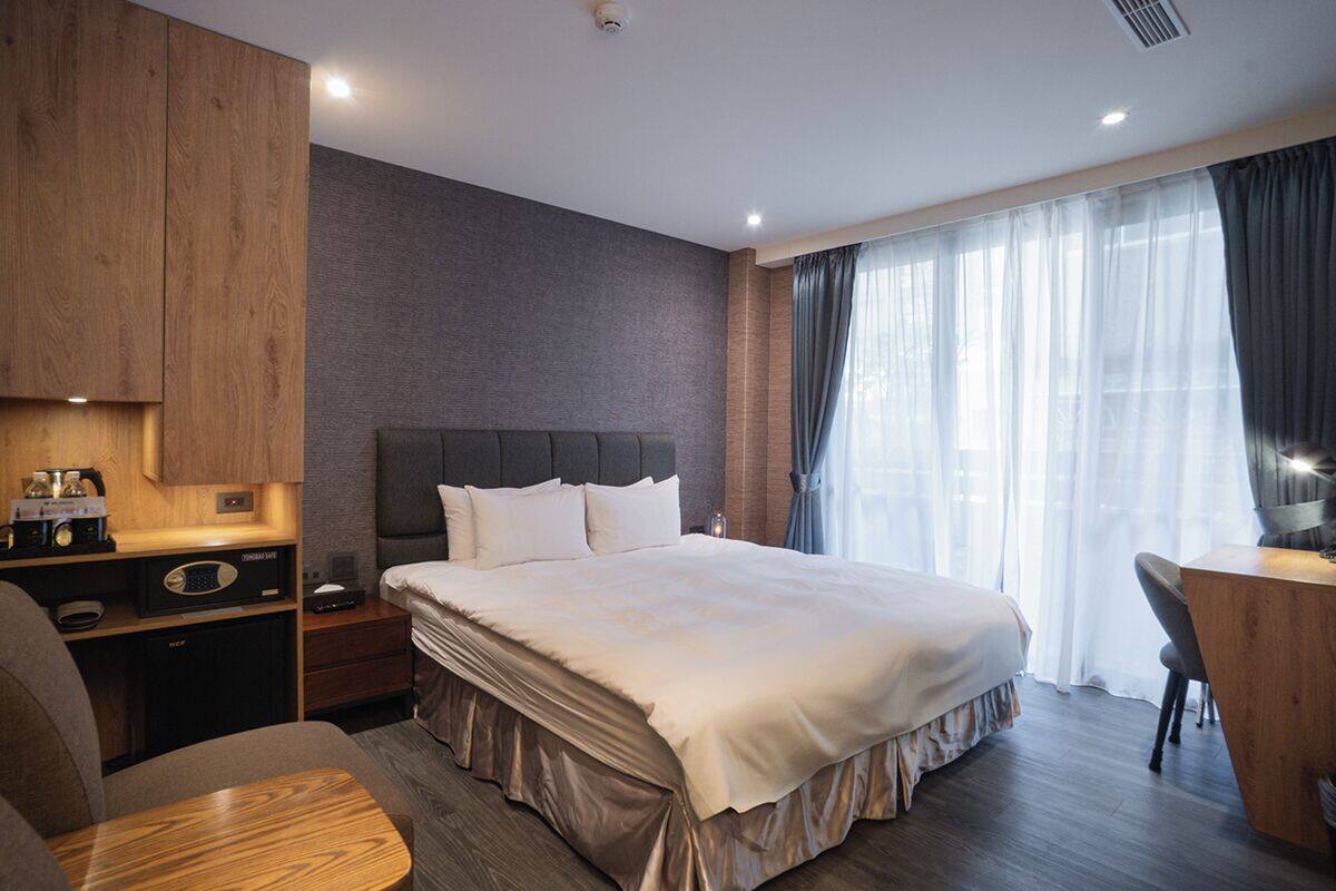 Une chambre d’hôtel moderne avec un grand lit, un bureau et une chaise.