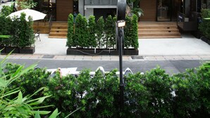 A modern building with multiple balconies, a visible restaurant named "Rose to Table," and a well-maintained outdoor area with potted plants. - Royal Rose Hotel Shuangcheng Hall (Taipei)