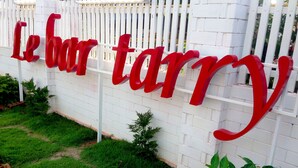A white fence with large red letters spelling "Le bar tanny". - Le Bar Tarry Hotel (Tha Li)
