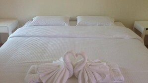 A neatly made bed with two pillows and two towels arranged in a heart shape on the bed. - Le Bar Tarry Hotel (Tha Li)