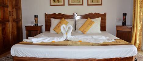 A neatly made bed with a wooden headboard, white bedding, and decorative pillows.