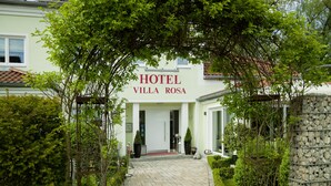 L’entrée d’un hôtel, avec une enseigne indiquant « HÔTEL VILLA ROSA ».