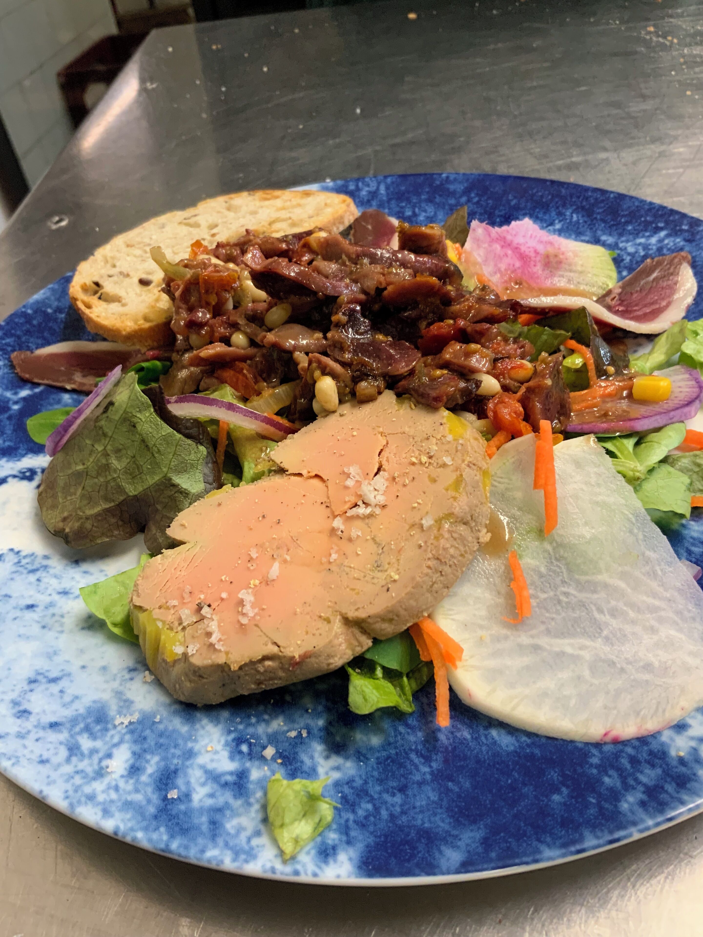 A plate with a variety of food items including bread, meat, and vegetables.